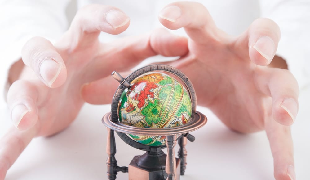 Hands surrounding a miniature globe