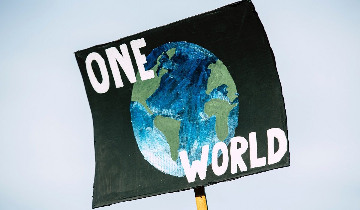 A protest sign saying "One world"