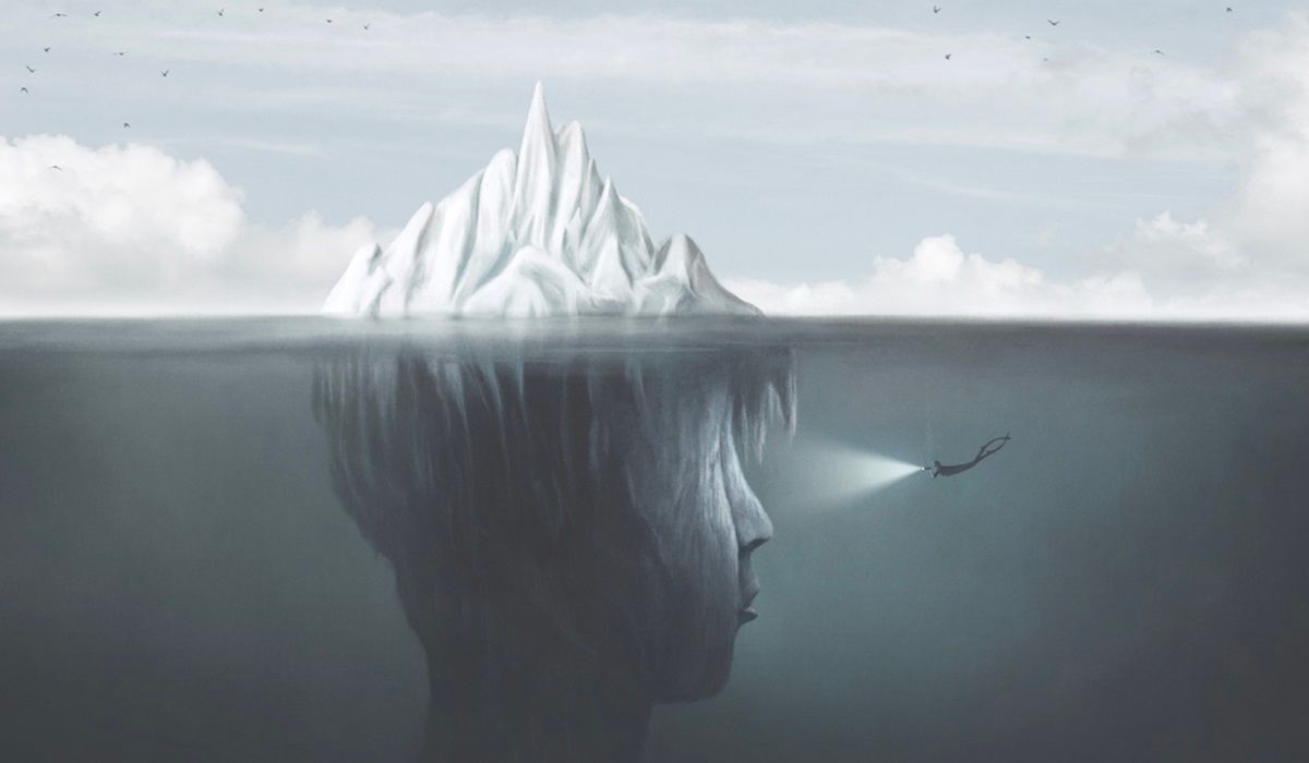 Surreal illustration of diver swimming below iceberg to reveal human head under the water